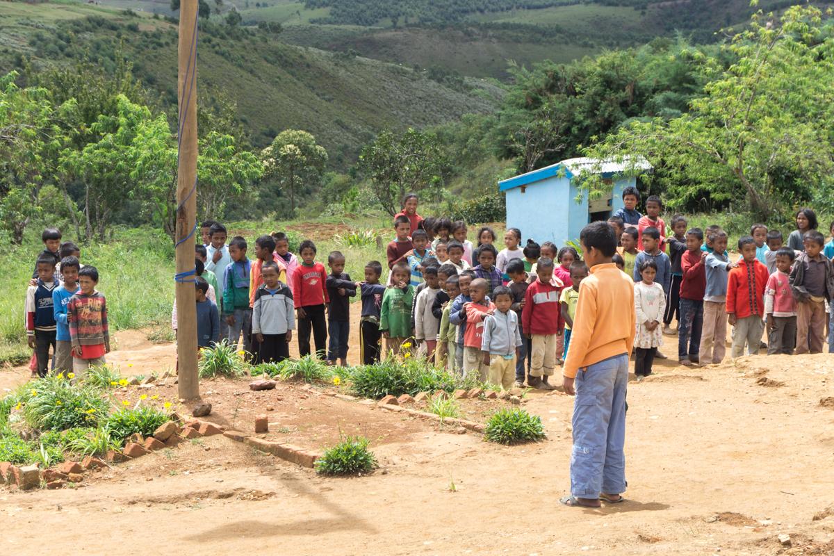 Foule d'enfants qui chantent l'hymne national de Madagascar devant l'école