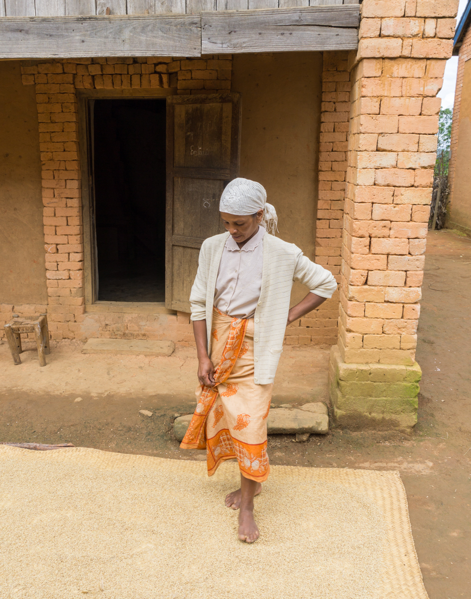 Dame malgache qui écrase des grains de riz à Anjozorobe, Madagascar