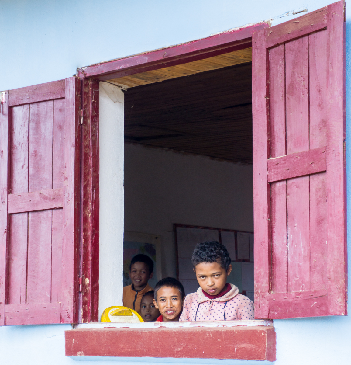 Enfants devant la fenêtre de l'école à Madagascar