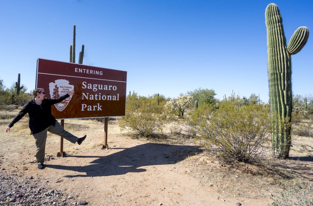 Jen près de l'affiche du Saguaro National Park plein de cactus en Arizona