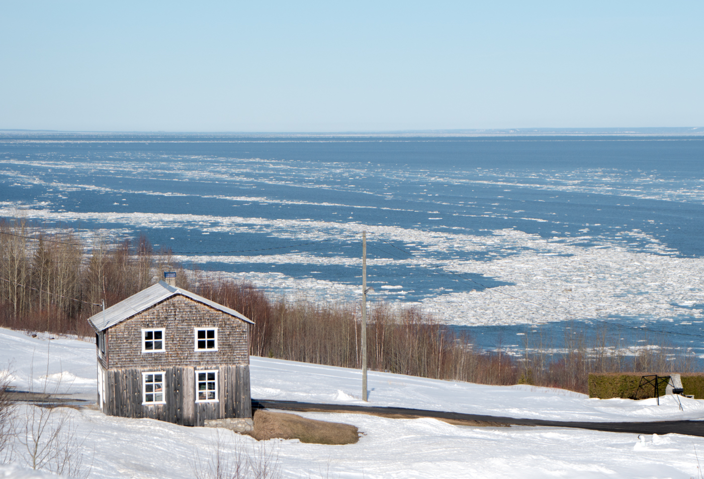 Petite maison blanche dans la neige de l'hiver de Charlevoix