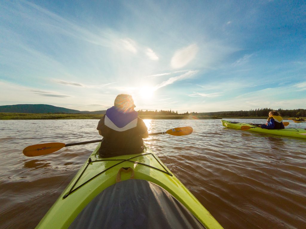 Kayak sur l'eau au coucher de soleil - Bucket list au Canada
