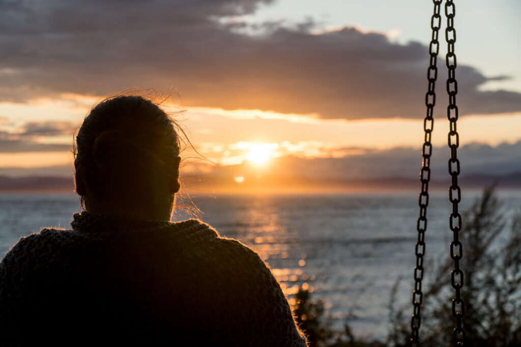 Anne assise sur un banc au coucher de soleil