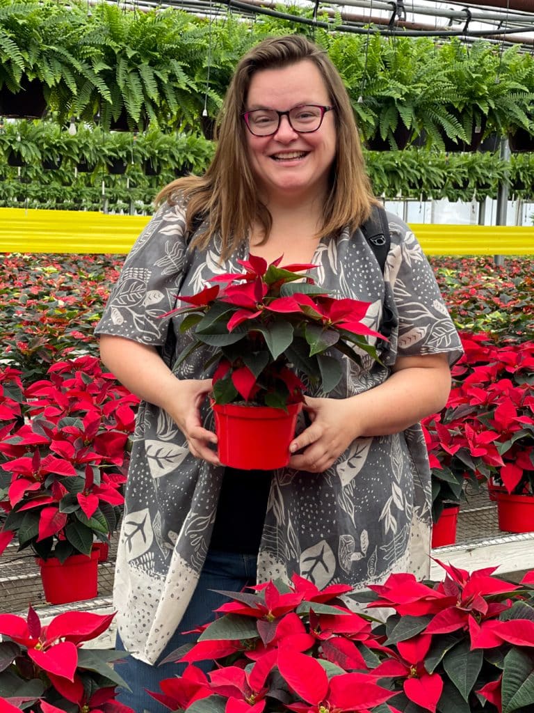 Jennifer avec un pot de poinsettia rouge - Activité à Laval