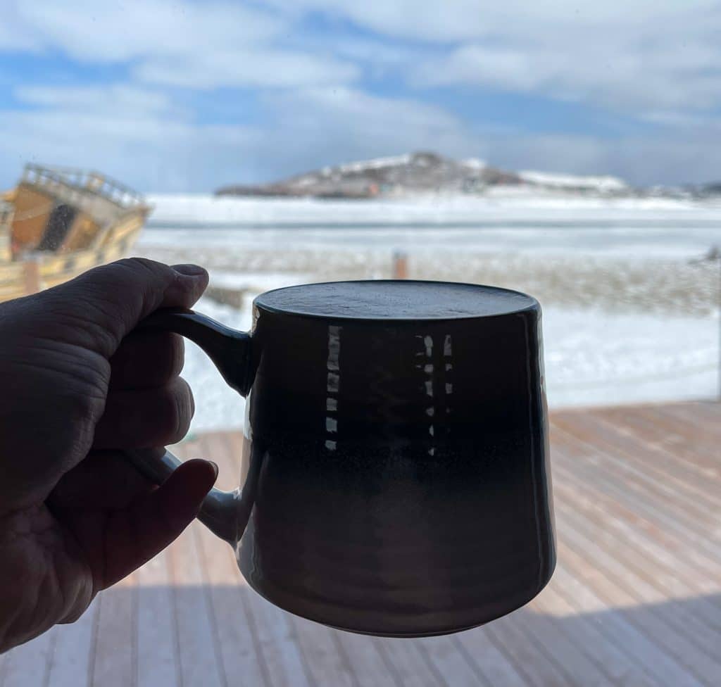 Tasse de café devant la petite baie à Havre-aux-Maisons