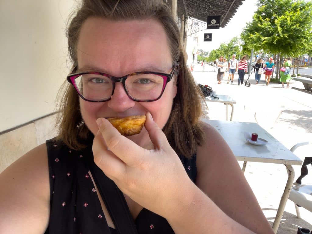 Jennifer qui mange une pasteis de nata au Portugal