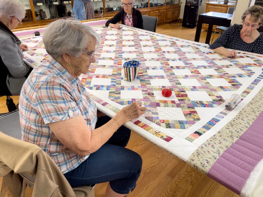 Femmes qui font une courtepointe au Musée des Acadiens des Pubnicos