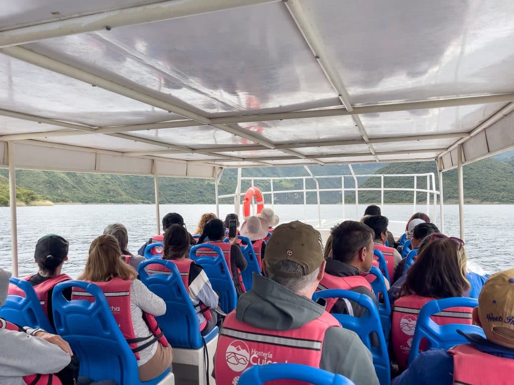 Gens sur un bateau dans la lagune de Cuicocha