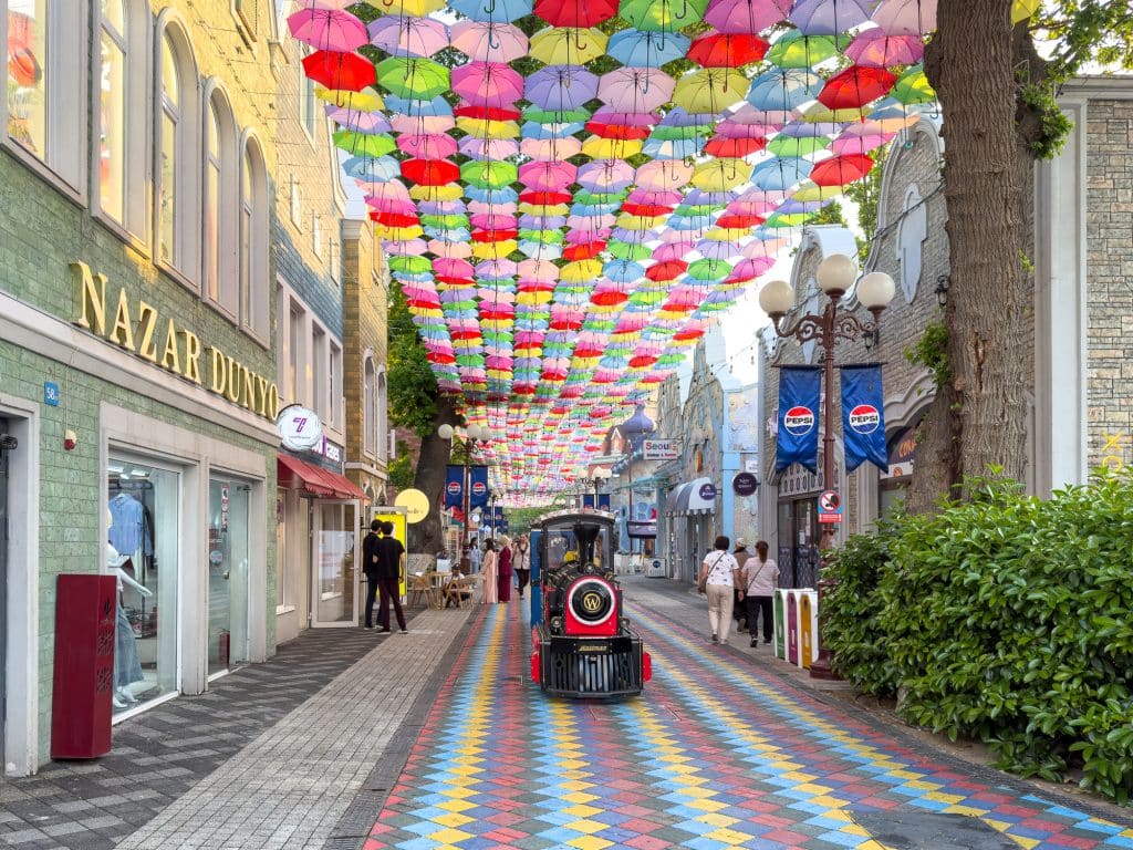 Allée avec train et parapluies à Magic CIty